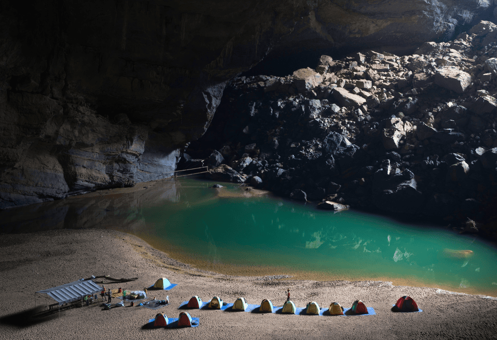 The expedition team sets up camp beside a tranquil underground river under Son Doong’s colossal ceiling (Source: Canva)